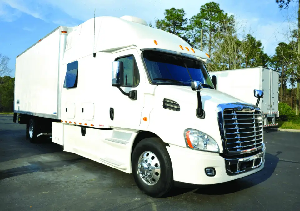 A large semi truck in motion, highlighting its powerful build and extensive cargo capacity on the highway.